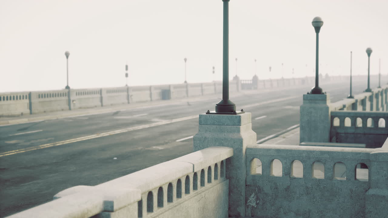 Foggy morning on a quiet coastal road with concrete barriers and lampposts