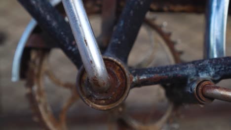 close up of the crank of a rusty old bicycle with the chain and the pedal