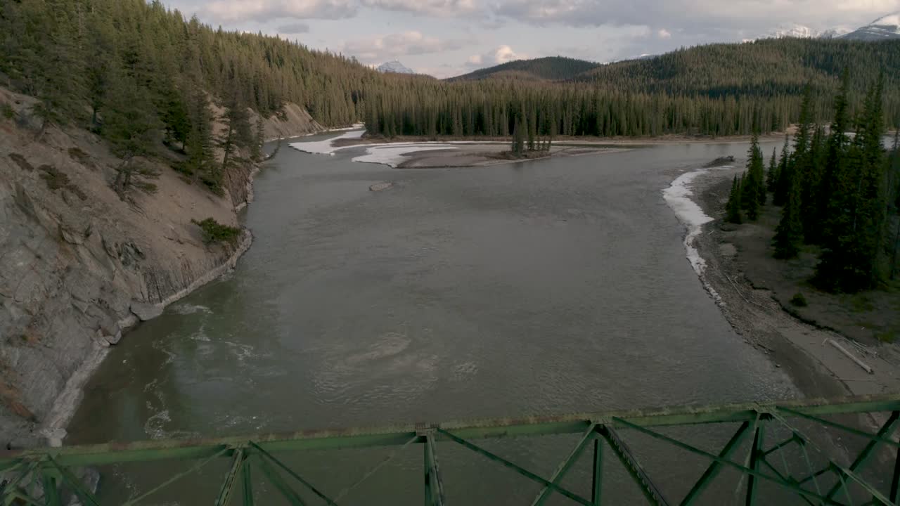 Canadian river in the Rocky Mountains. Aerial drone footage above a bridge.