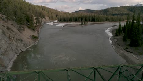 canadian river in the rocky mountains. aerial drone footage above a bridge.