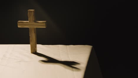 religious concept shot with wooden cross on altar in pool of light 2