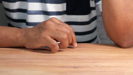 la mano de una persona en una mesa de madera