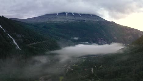 Scenic-aerial-down-misty-Vestfjord-valley-with-view-of-Gaustatoppen-mountain