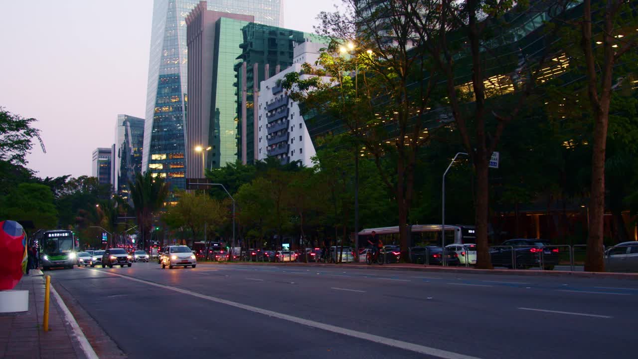 In São Paulo’s evening glow, urban commuting traffic headlights flow
