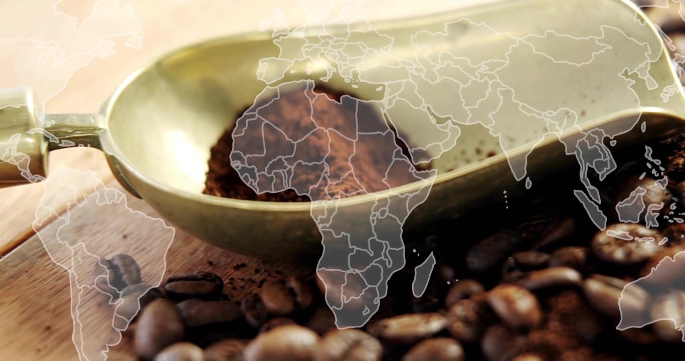 Primer plano inicial de una cuchara de café de latón con café molido, mostrando el origen global del café con un mapa superpuesto