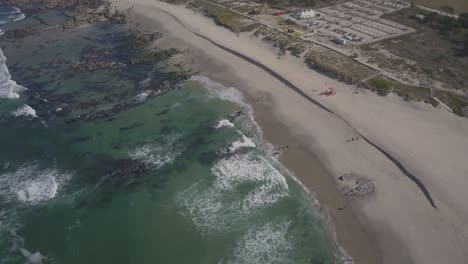 4k-uhd-luftdrohnenaufnahmen-Eines-Perfekten-Leeren-Strandes-Mit-Langen-Wellen,-Die-An-Einem-Schönen-Sonnigen-Tag-Am-Atlantik-In-Minho-Am-Ufer-Rollen