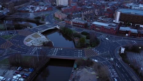 aerial view looking down city centre canal roundabout infrastructure suburban streets traffic at daybreak right orbit