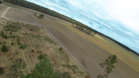 vuelo aéreo fpv sobre campos agrícolas en el campo durante el día nublado y soleado
