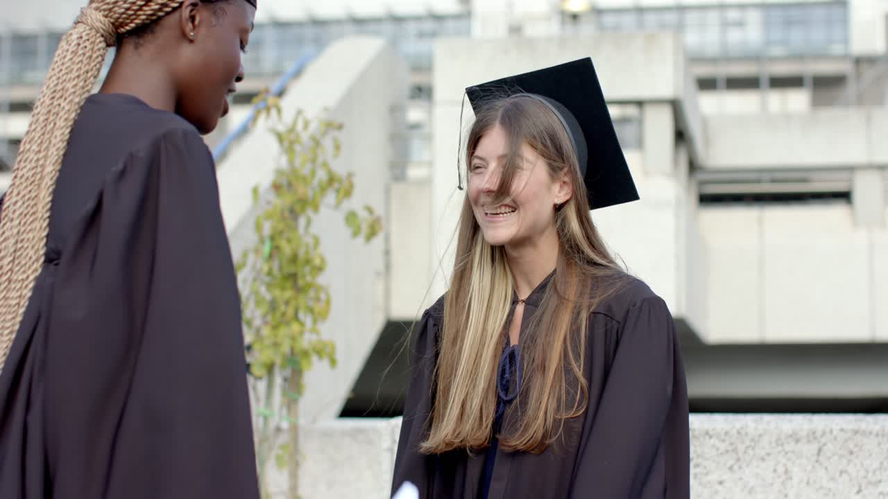 Mujeres diversas graduadas, que tocan con alegría el birrete, entregan un pergamino y celebran en la plaza