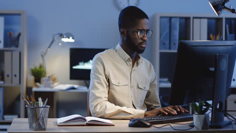 Young-Man-Working-On-The-Computer-When-Getting-A-Message-On-His-Smartphone-And-It-Cheering-Him-Up-1