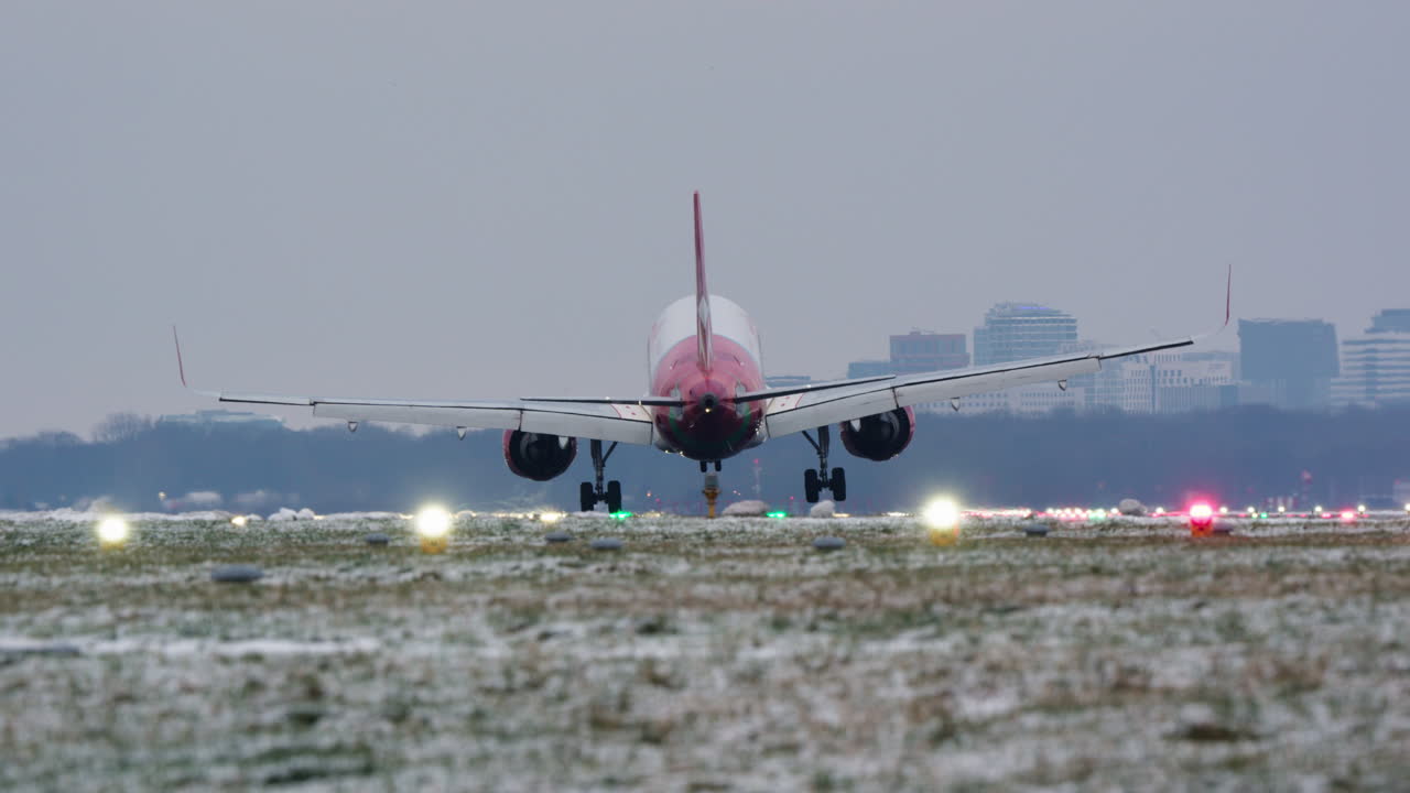 Grande aereo passeggeri che atterra su una pista innevata dell'aeroporto
