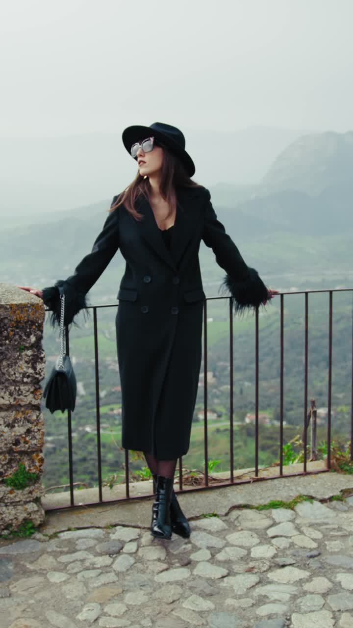 Elegant Model Posing On The Railing With A Mountain Landscape Background