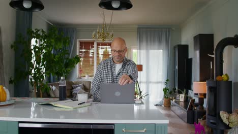 hombre trabajando desde casa en la cocina