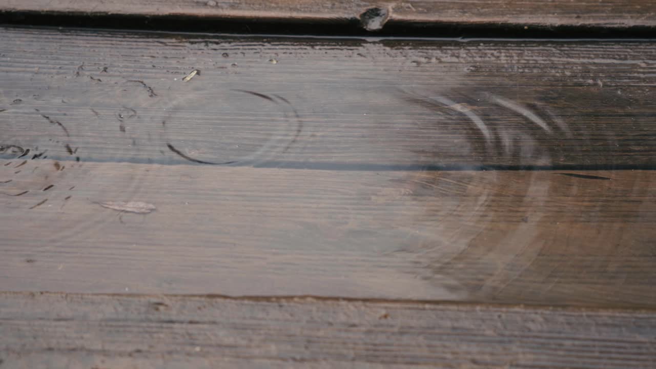 Rainy weather, a drop of water falls into a puddle at the entrance to a house