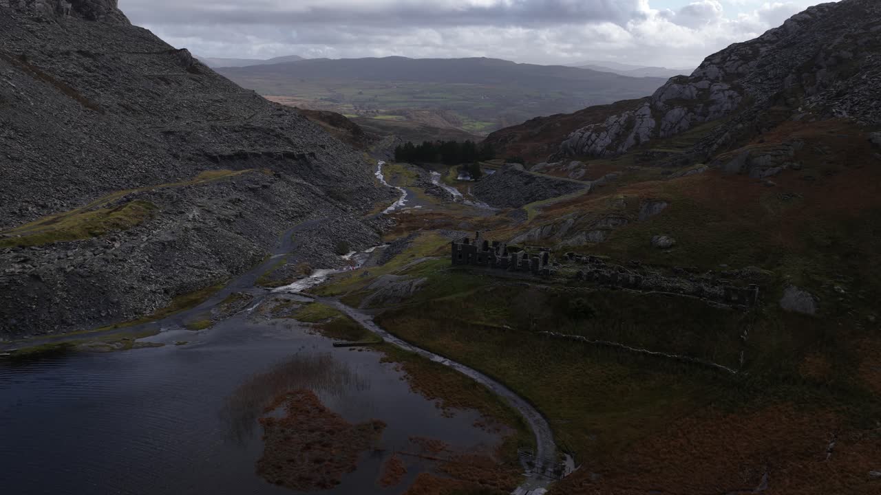 Aerial drone footage of Llyn Cwmorthin and the Moelwyn Mawr range in Eryri National Park, capturing serene lakeside scenery, dramatic Welsh mountains, and the region’s slate-mining heritage