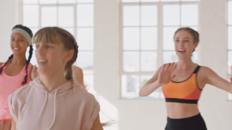 Feliz-Mujer-Caucásica-Bailando-Grupo-De-Personas-Sanas-Disfrutando-Del-Entrenamiento-Practicando-Movimientos-De-Baile-Coreográficos-Divirtiéndose-En-El-Gimnasio