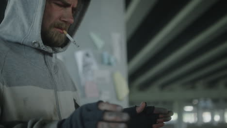 homeless man smoking and warming hands over fire