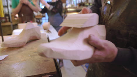 zapatero a medida comprobando el último de madera para el zapato usando el rompecabezas