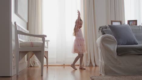 hermosa niña bailando juguetón fingiendo ser bailarina niño feliz divirtiéndose jugando a vestirse con traje de ballet con alas de hada en casa 4k