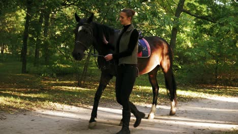 Junge-Attraktive-Frau,-Die-Im-Herbst-Mit-Dem-Pferd-Im-Wald-Spaziert