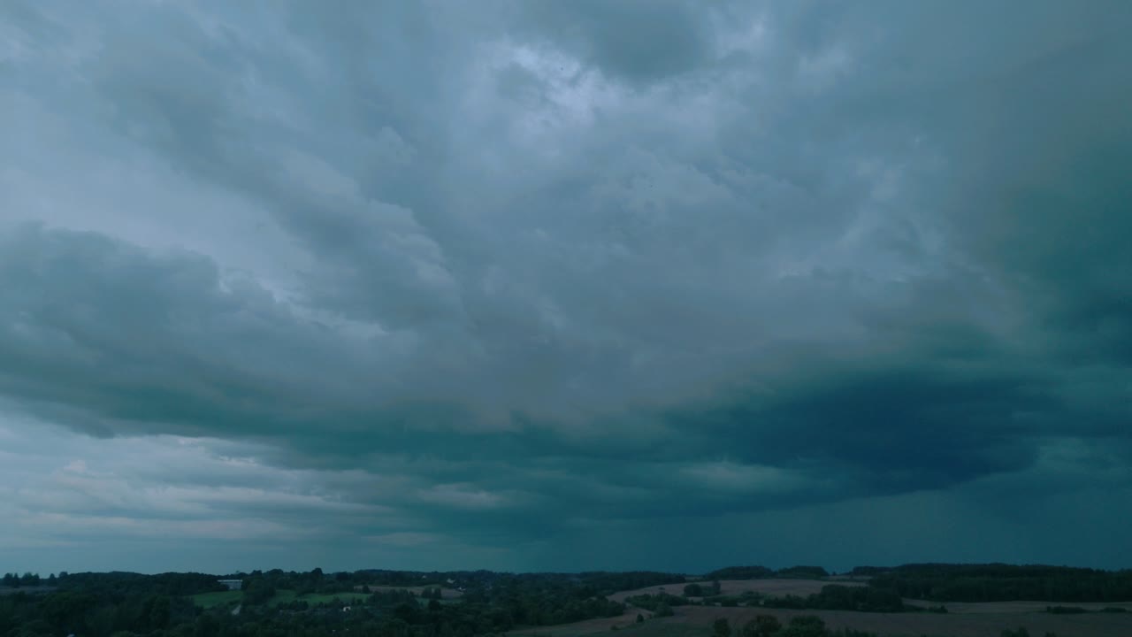 불길한, 어두운 구름이 발트 해의 풍경 위에 모이는 공중 풍경, 폭풍 전에 강렬하고 극적인 분위기를 포착합니다.