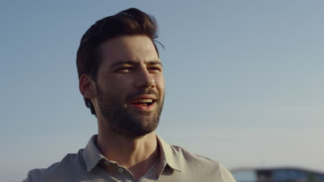 Sexy-guy-smiling-outdoors.-Young-man-face-laughing-looking-distance-on-blue-sky.