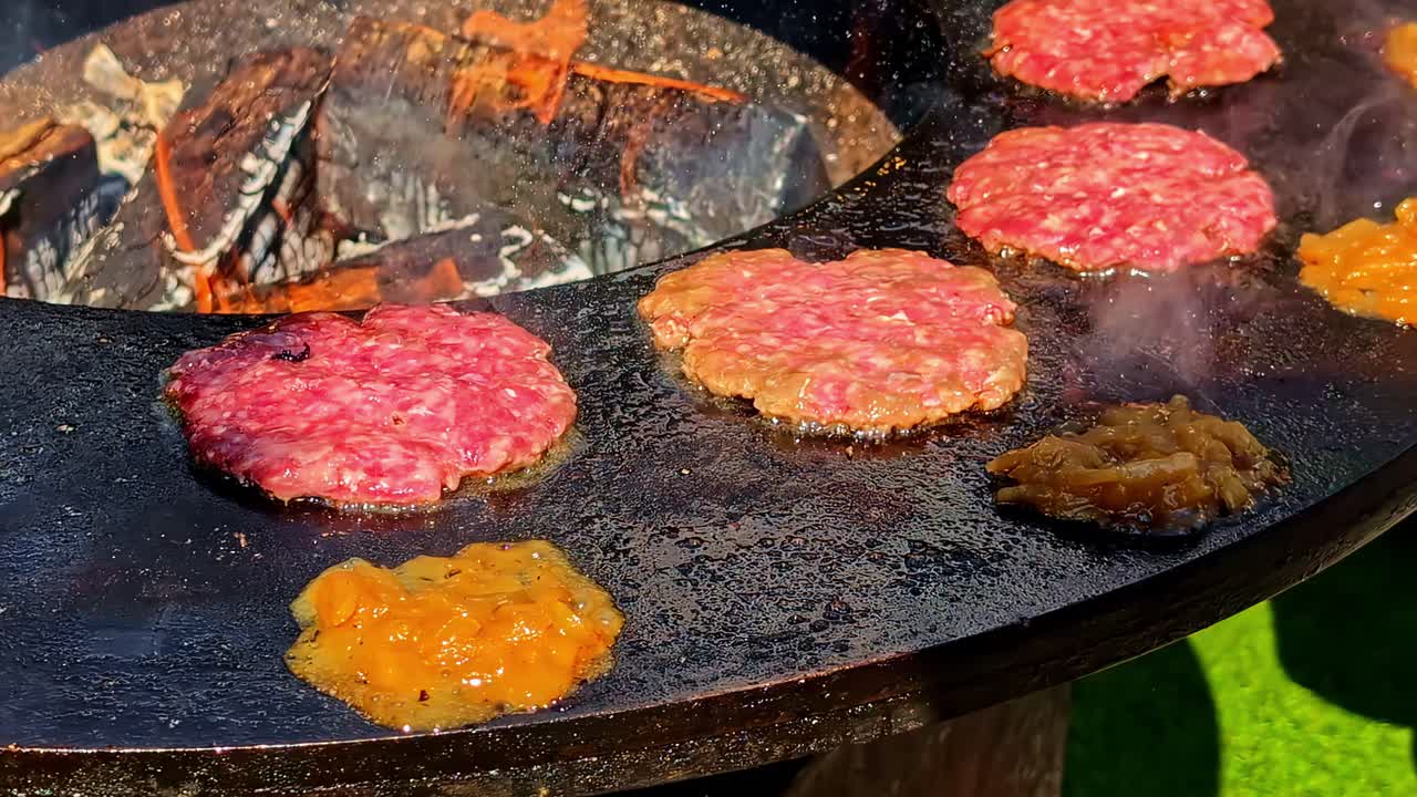 Delicious juicy burgers sizzling on the hot grill. Handheld close up