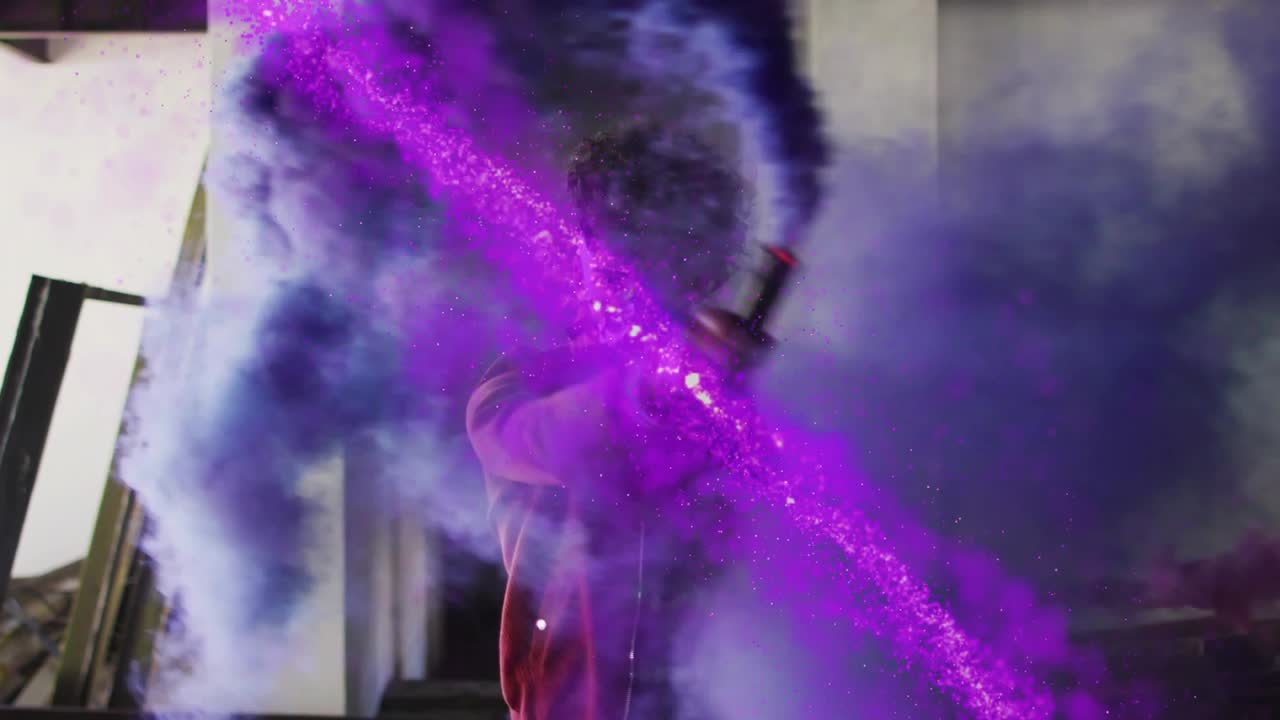 Man raising smoke canister, sweeping arms and mixing purple blue-gray plumes for visual effects