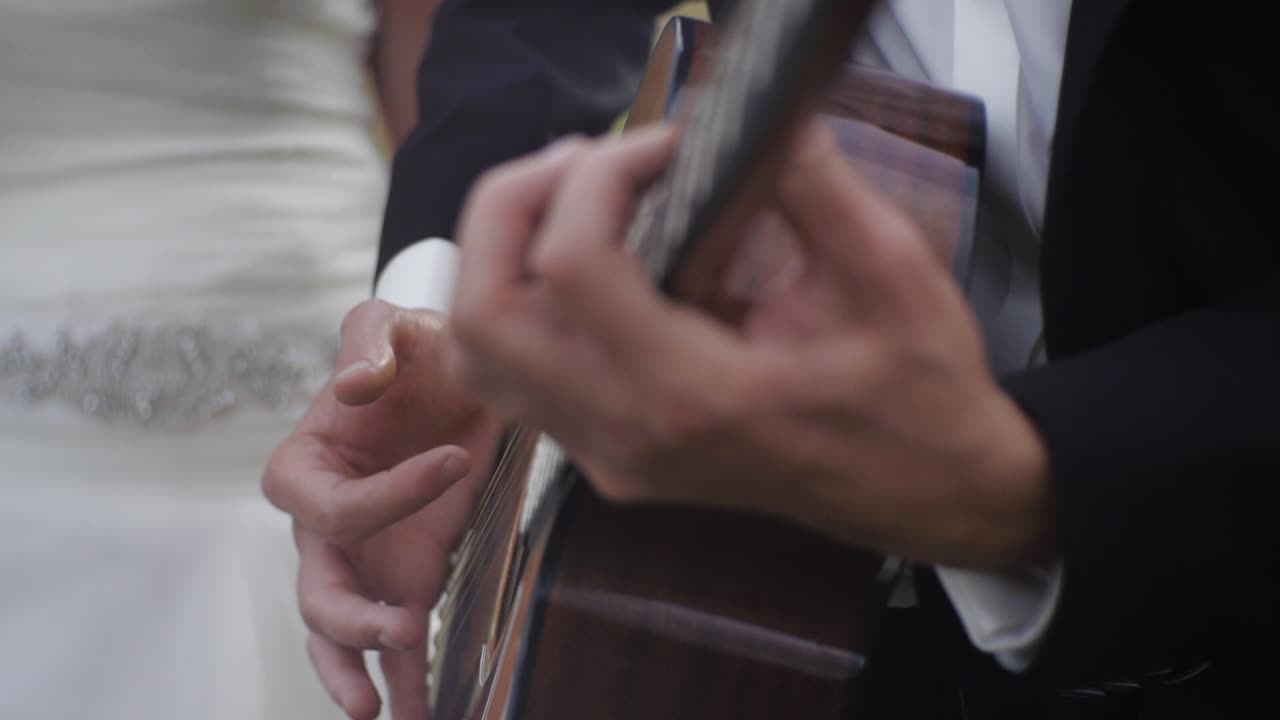 Groom playing a guitar for a bride - close up