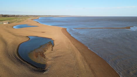 aerial image shingle street , beach suffolk lone remote cottage reveal shot bright sunny day