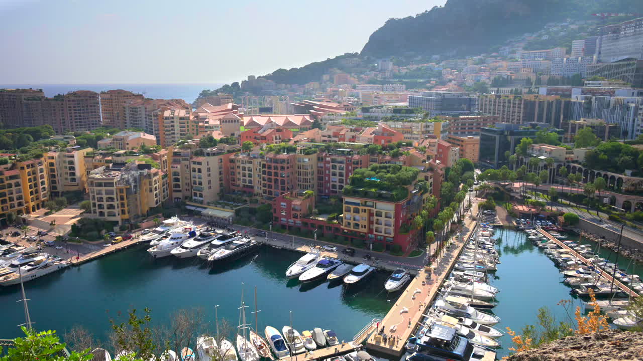 View of boats docked in the Monaco Marina with the skyline of the city on the background