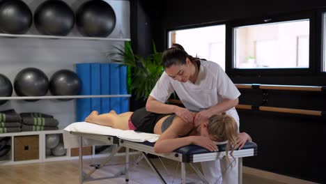 terapeuta femenina masajeando los hombros del paciente
