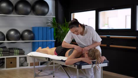 female therapist massaging shoulders of patient