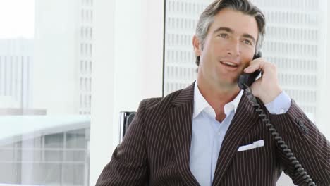 attractive businessman on phone in office