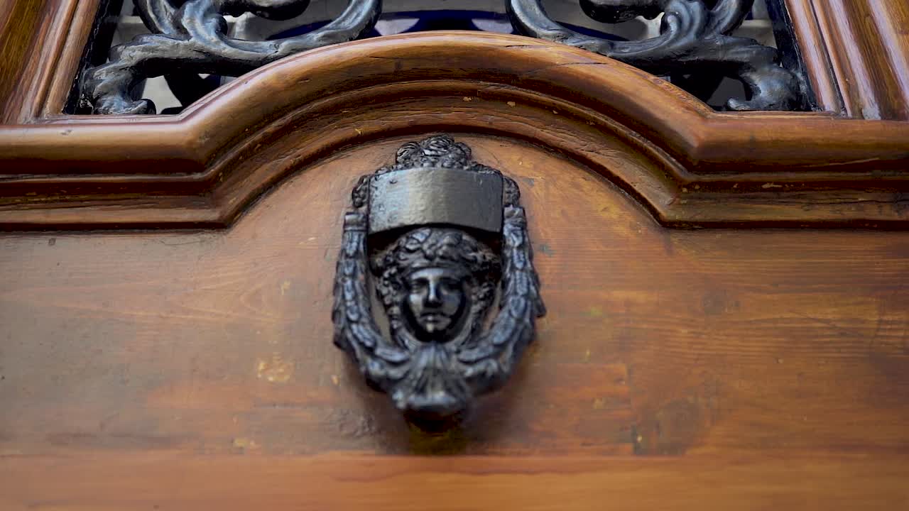 금속 얼굴 두드리는 사람이 있는 오래된 나무 문