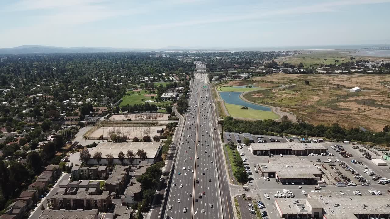 vista aérea de pinos automóviles autopista 101 suburbios árboles densos azotea casas marsh transformadores eléctricos avanzar