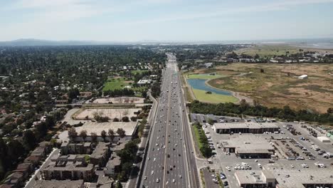 Vista-Aérea-De-Pinos-Automóviles-Autopista-101-Suburbios-árboles-Densos-Azotea-Casas-Marsh-Transformadores-Eléctricos-Avanzar