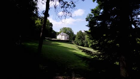 Emerging-from-the-Forest-to-Reveal-Vast-Lawn-and-Southern-France-Castle-under-Blue-Sky