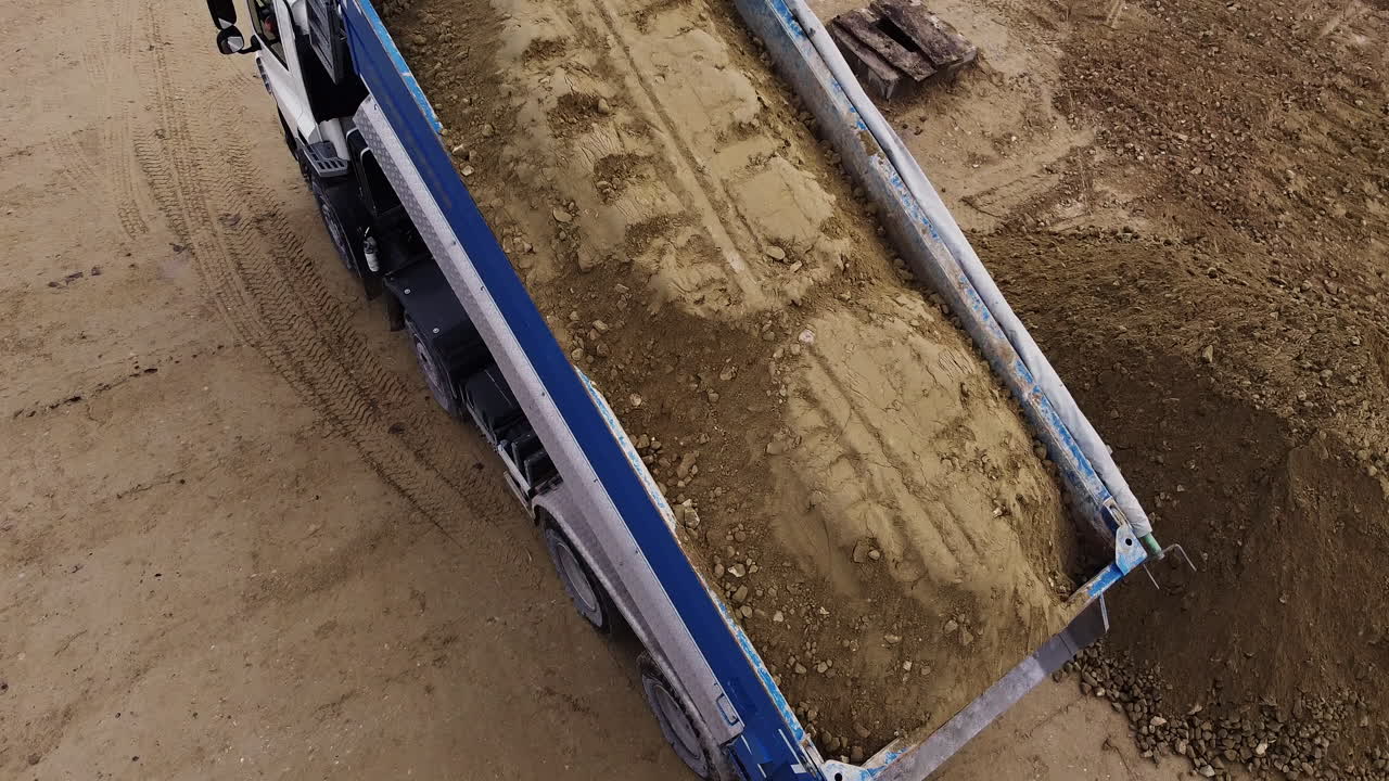 Dump Truck Loading/Unloading Dirt at Construction Site