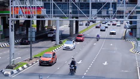 car and motorbike traffic on 3 lane highway road in capital city of kuala lumpur malaysia