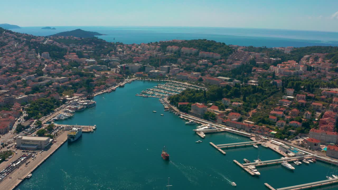 Aerial panning shot of a old sailing boat approaching the port of Dubrovnik