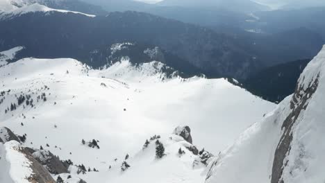 Las-Montañas-Ciucas-Cubiertas-De-Nieve-Bajo-Un-Cielo-Nublado,-Vista-Aérea