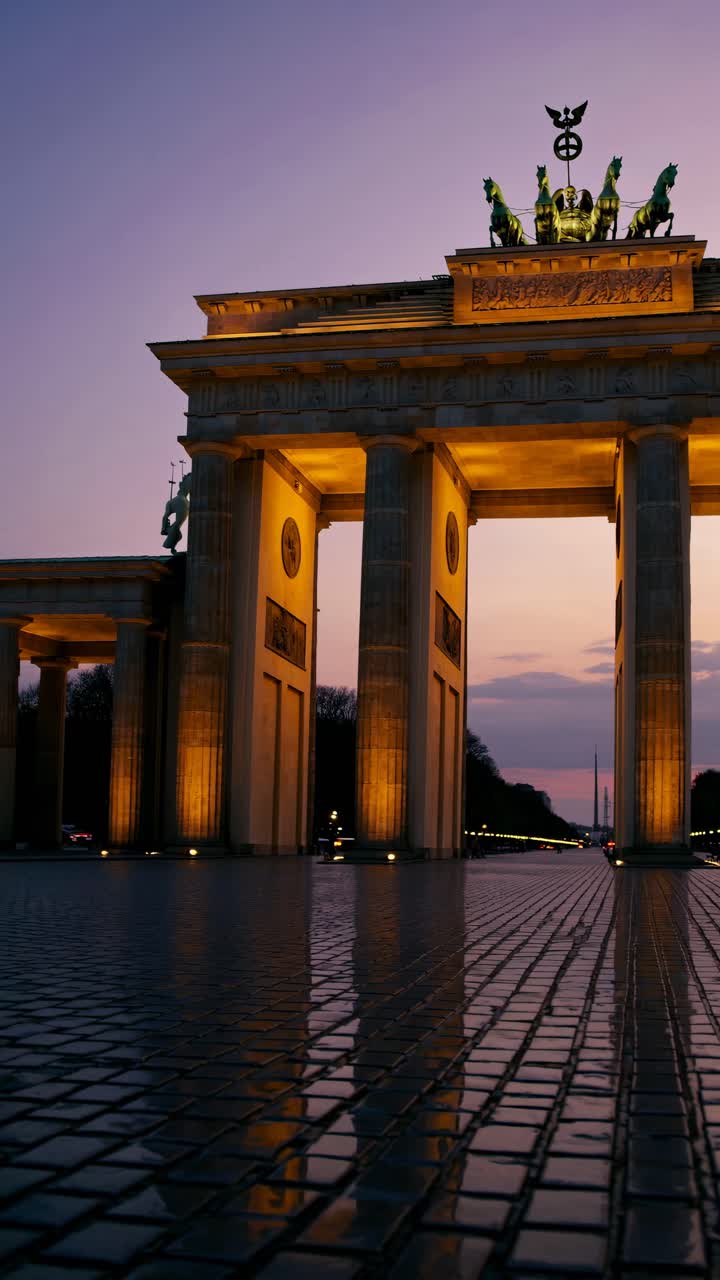 Videooptagelse i lav engel af Brandenburger Tor ved tusmørke, der fremhæver dens oplyste søjler