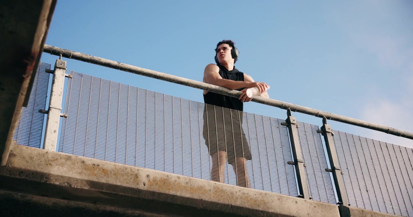 Young Man Resting on Bridge After Running