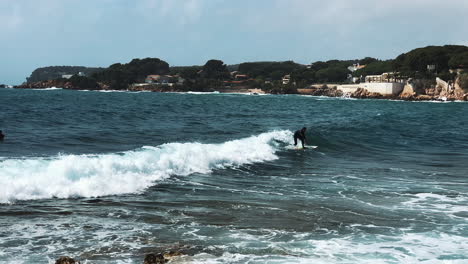 surfer riding a wave at the coastline