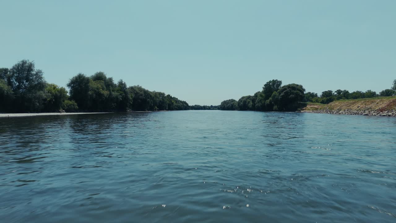 calm aerial flyover of the Sava River flowing past green banks near Zagreb in summer sunlight