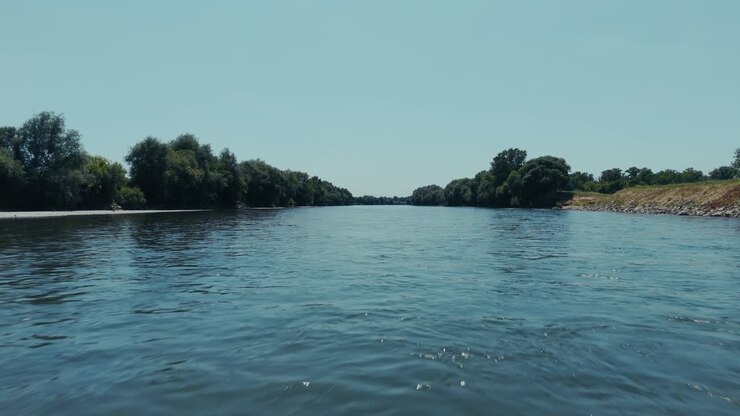 calm aerial flyover of the Sava River flowing past green banks near Zagreb in summer sunlight