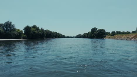 calm aerial flyover of the sava river flowing past green banks near zagreb in summer sunlight