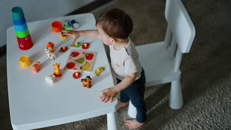 toddler baby learning fruit. caucasian child plays on the little table. view from top.