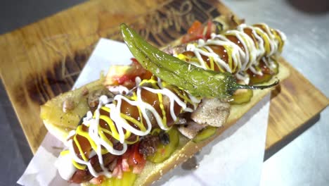 lenta creación de un tiro de un perrito caliente cargado y papas fritas listas para ser servidas